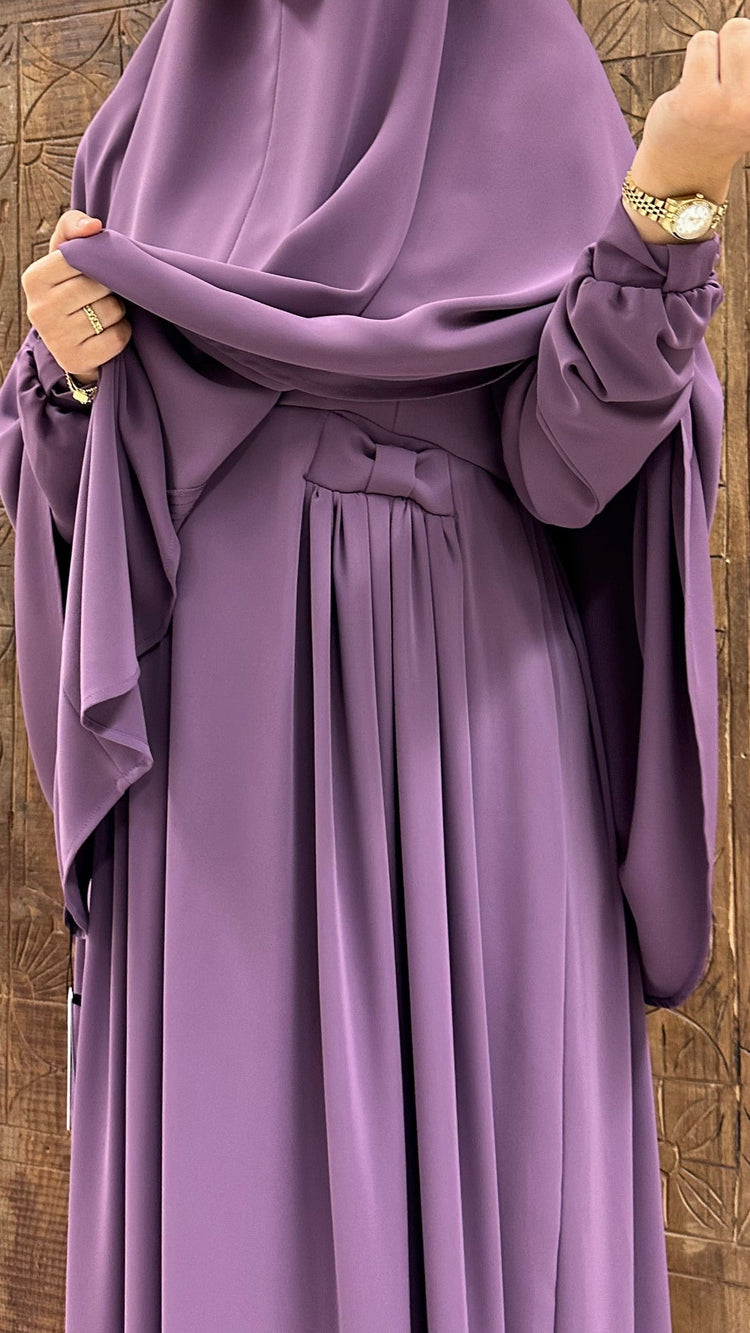 Luxe paarse abaya met handgemaakte borduursels en elegante plooien, perfect voor een klassieke modest fashion look.
