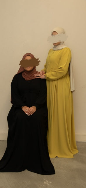 Abaya met subtiele plooien en luxe uitstraling, perfect voor zowel formele als informele gelegenheden.