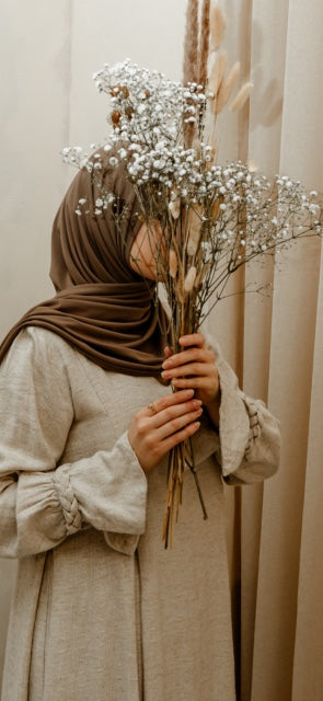 Luxe abaya met handgemaakte borduursels en elegante plooien, perfect voor een klassieke modest fashion look.
