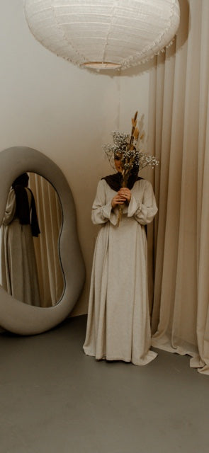 Luxe abaya met handgemaakte borduursels en elegante plooien, perfect voor een klassieke modest fashion look.