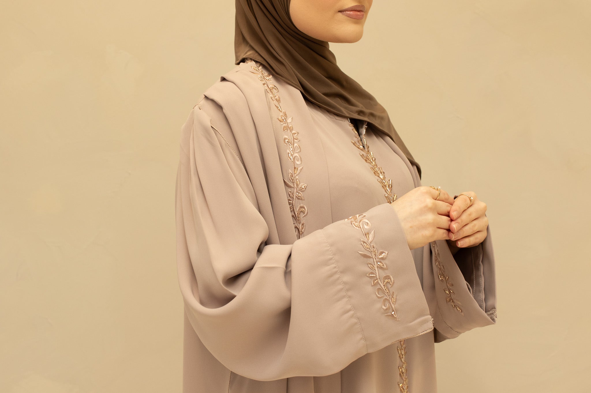 Feestelijke abaya met subtiele glans en delicate details, ideaal voor speciale gelegenheden en avondlooks.